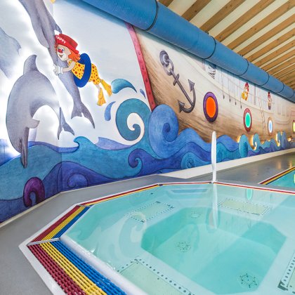 Nahaufnahme des Pools mit maritimem Wanddesign, Delfinen und Piratenmotiv.