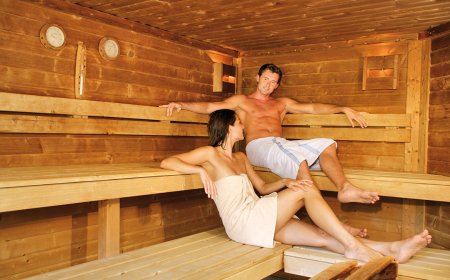 Ein Paar entspannt in einer Sauna.