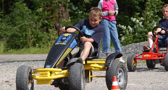 Kinder fahren auf Kettcars.